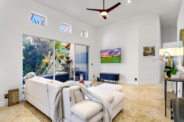 living room with ceiling fan and a high ceiling