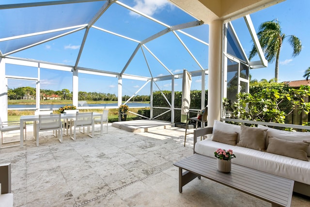 view of patio / terrace featuring an outdoor hangout area, glass enclosure, and a water view