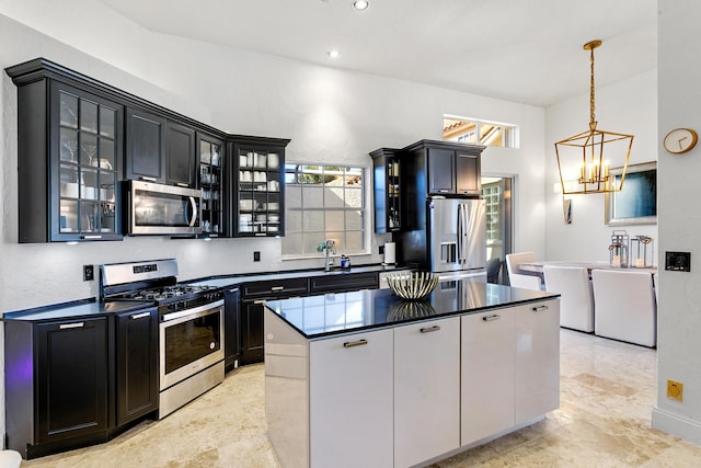 kitchen with a chandelier, a kitchen island, stainless steel appliances, and pendant lighting