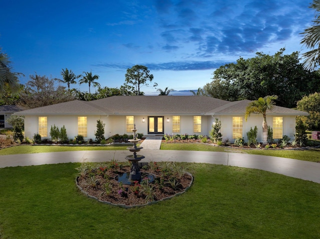 ranch-style home with french doors and a yard