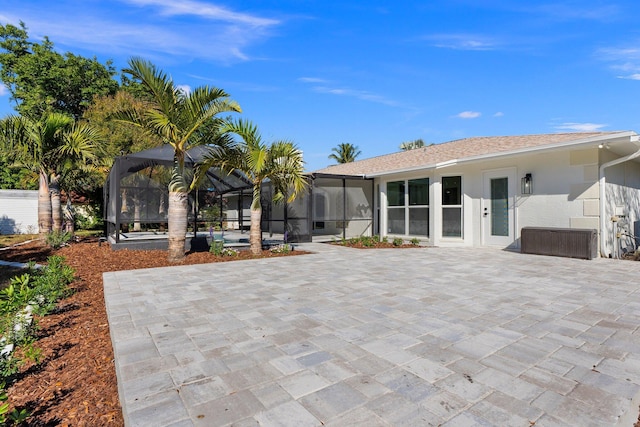 back of house with a patio area and glass enclosure