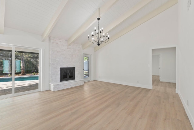 unfurnished living room featuring a chandelier, light hardwood / wood-style flooring, a stone fireplace, and high vaulted ceiling