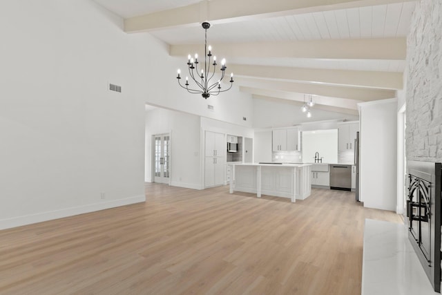 unfurnished living room featuring light hardwood / wood-style floors, beamed ceiling, sink, high vaulted ceiling, and a chandelier