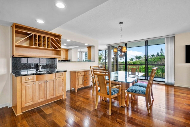 dining area featuring floor to ceiling windows, sink, a textured ceiling, dark hardwood / wood-style flooring, and a chandelier