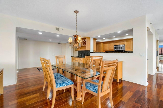 dining room featuring dark hardwood / wood-style floors and an inviting chandelier