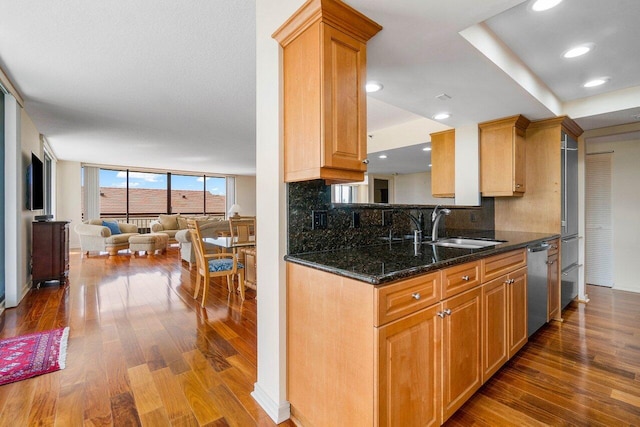 kitchen featuring dark wood-type flooring, dark stone countertops, decorative backsplash, sink, and floor to ceiling windows