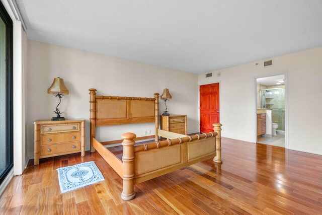 bedroom featuring light wood-type flooring and connected bathroom