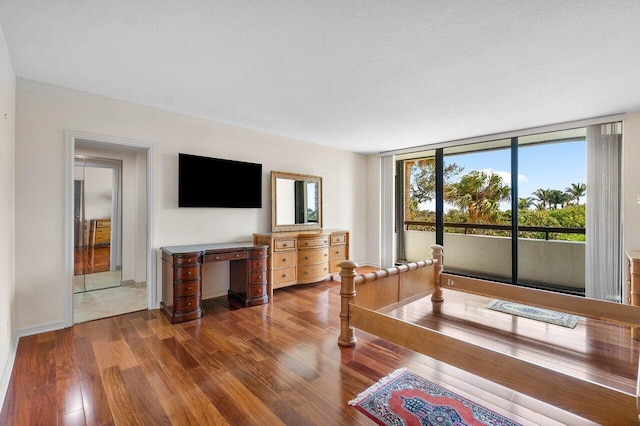 unfurnished bedroom featuring a textured ceiling, dark wood-type flooring, and access to exterior