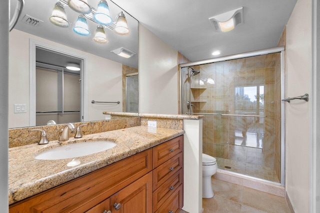 bathroom featuring toilet, vanity, tile patterned floors, and walk in shower