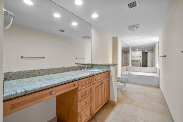 bathroom featuring tile patterned flooring, vanity, toilet, a washtub, and a bidet