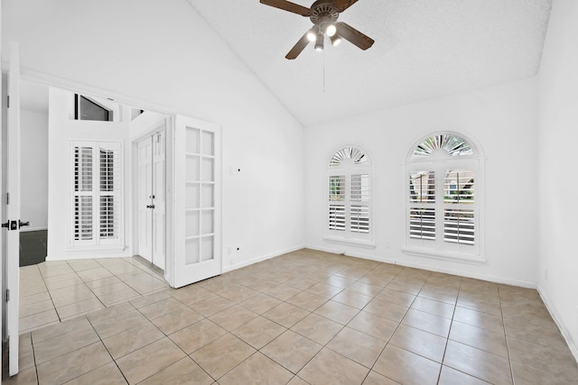 tiled spare room featuring ceiling fan, a textured ceiling, and high vaulted ceiling