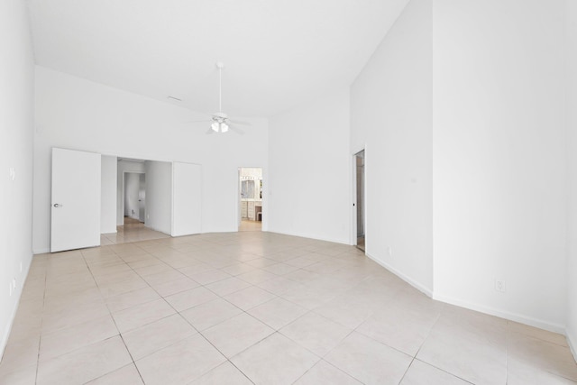 tiled spare room featuring ceiling fan and high vaulted ceiling