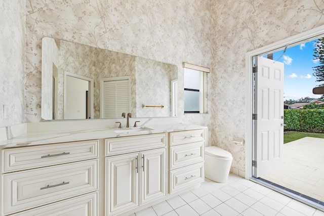 bathroom with tile patterned flooring, vanity, a healthy amount of sunlight, and toilet