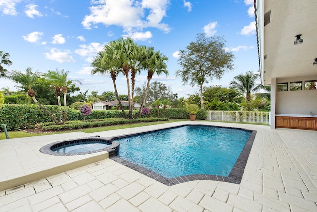 view of swimming pool featuring a patio and an in ground hot tub