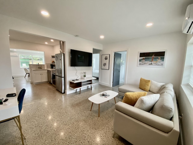 living room featuring an AC wall unit and sink