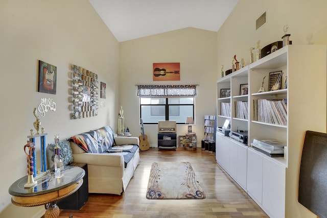 sitting room with light hardwood / wood-style floors and vaulted ceiling