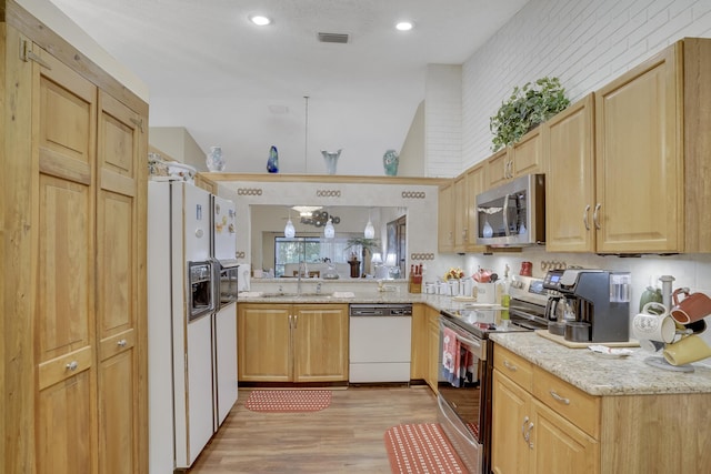 kitchen featuring light hardwood / wood-style floors, sink, light brown cabinets, stainless steel appliances, and light stone counters