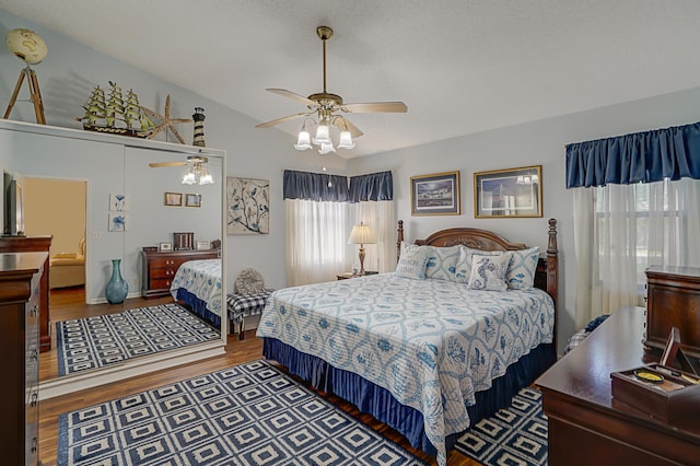 bedroom featuring ceiling fan, hardwood / wood-style floors, and a textured ceiling