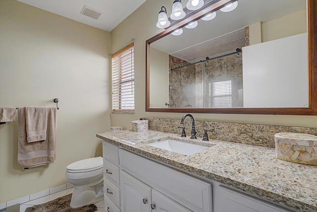 bathroom featuring a shower with shower door, vanity, tile patterned floors, and toilet