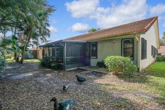 rear view of house featuring a sunroom