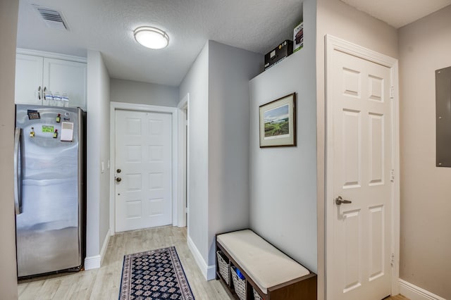 mudroom with a textured ceiling and light hardwood / wood-style flooring