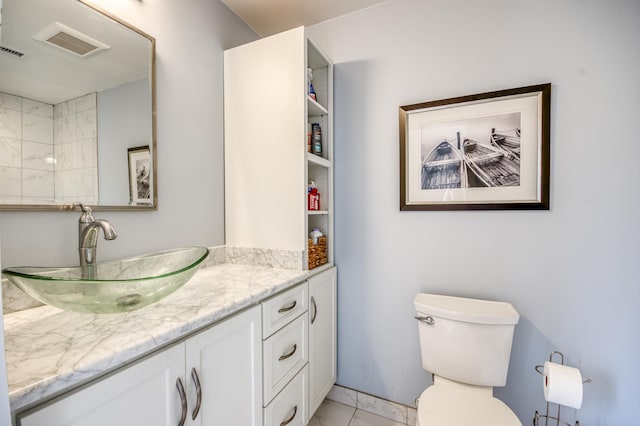 bathroom with tile patterned flooring, vanity, and toilet