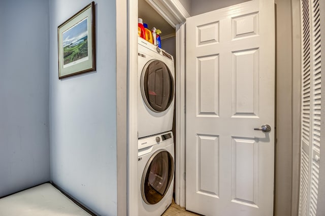 clothes washing area featuring stacked washer and dryer