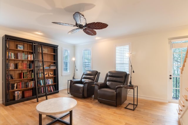 living area featuring crown molding, ceiling fan, and light hardwood / wood-style flooring