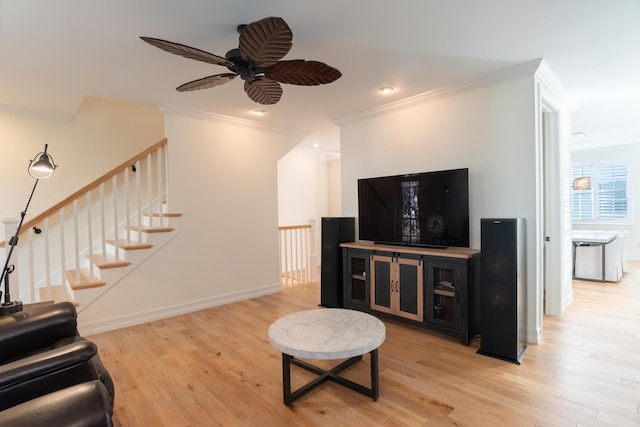 living room with crown molding, ceiling fan, and light hardwood / wood-style floors