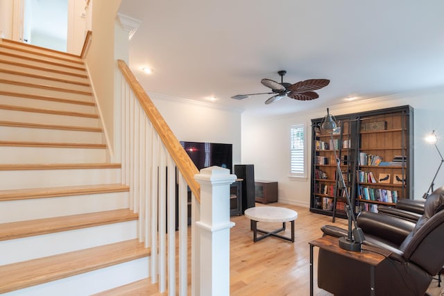 living room featuring crown molding, ceiling fan, and light hardwood / wood-style floors