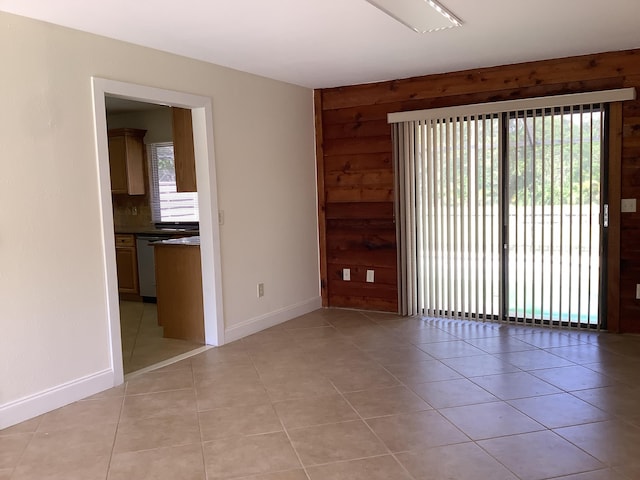 tiled spare room featuring wooden walls