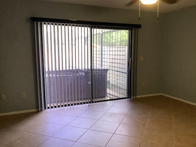 tiled spare room with ceiling fan