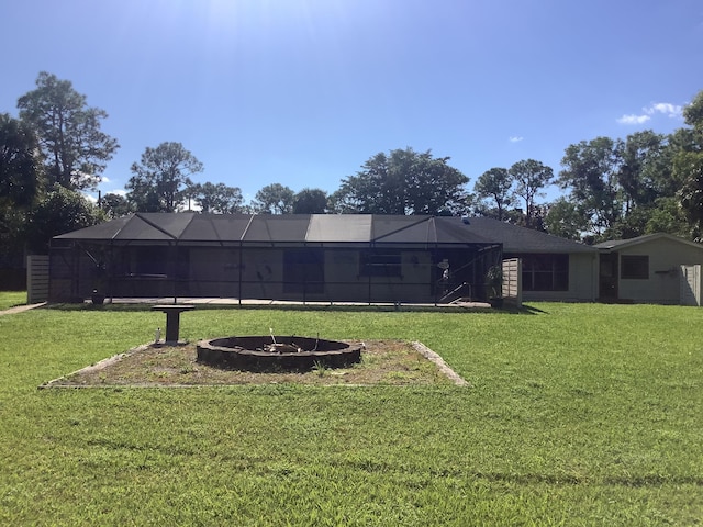 view of yard with an outdoor fire pit and glass enclosure