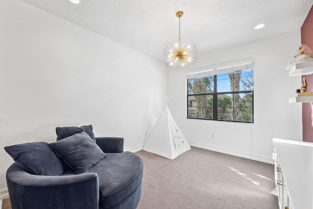 sitting room featuring a notable chandelier, a textured ceiling, and carpet flooring