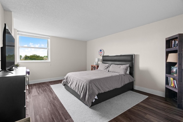 bedroom with a textured ceiling and dark wood-type flooring