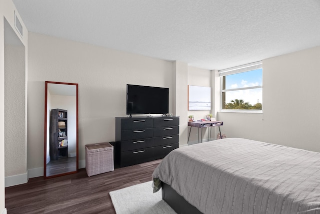 bedroom featuring dark wood-type flooring and a textured ceiling