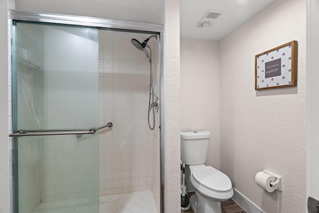 bathroom featuring toilet and an enclosed shower