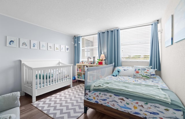 bedroom featuring a textured ceiling, dark wood-type flooring, and multiple windows