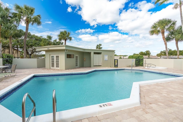 view of pool with french doors and a patio