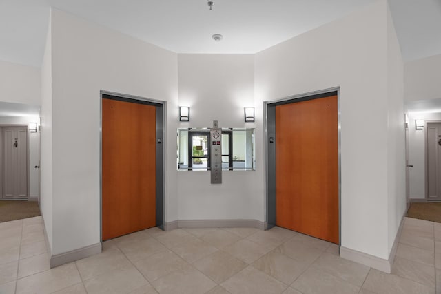 hallway with light tile patterned floors and elevator