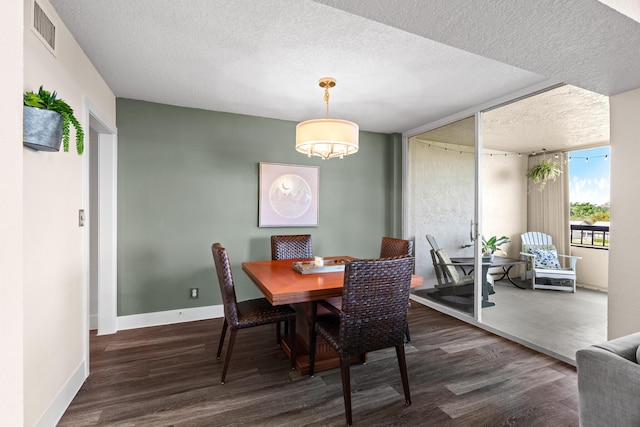 dining space featuring a textured ceiling and dark hardwood / wood-style floors