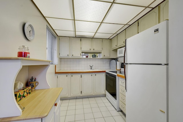 kitchen featuring sink, white appliances, light tile patterned floors, and tasteful backsplash