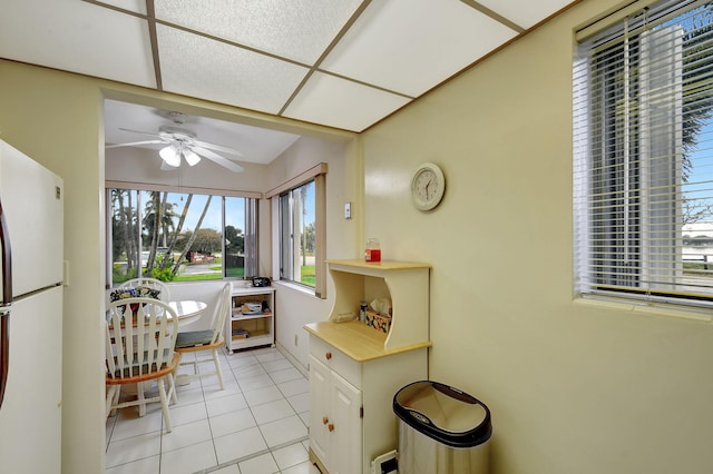 kitchen featuring white fridge, ceiling fan, and light tile patterned floors