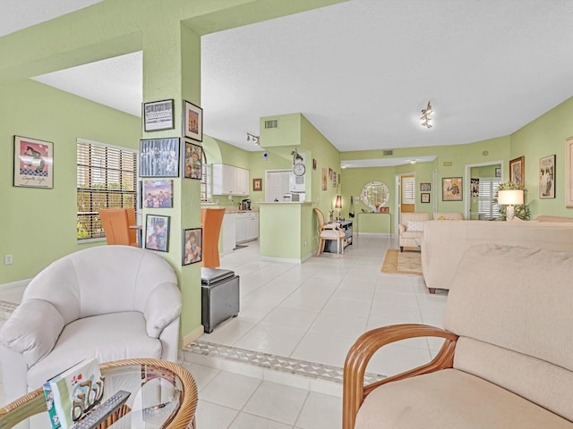 tiled living room featuring a textured ceiling