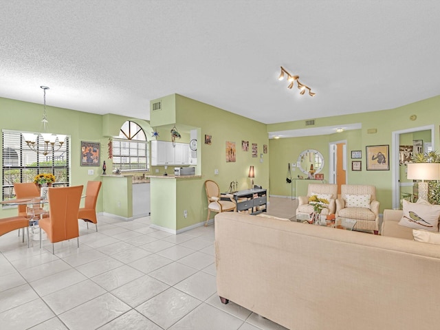 living room featuring light tile patterned floors, a chandelier, and a textured ceiling