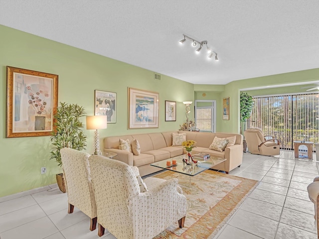 living room featuring light tile patterned floors, a textured ceiling, and rail lighting