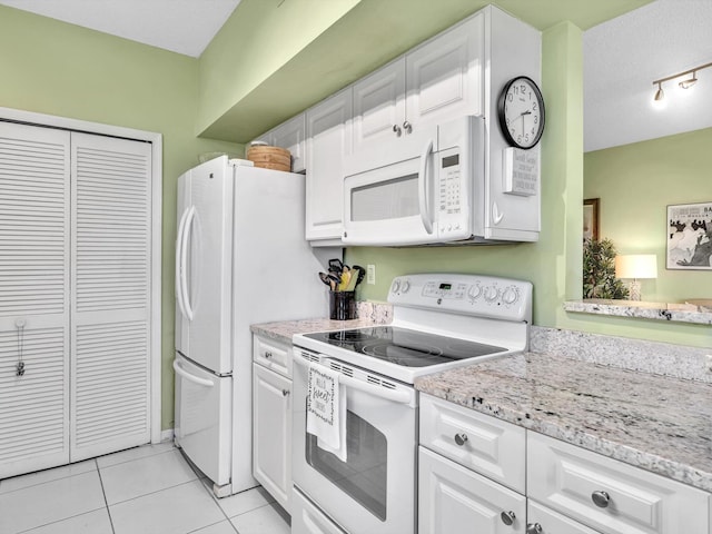 kitchen featuring light tile patterned floors, white appliances, a textured ceiling, white cabinets, and light stone counters