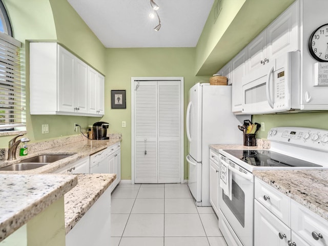 kitchen featuring sink, white appliances, white cabinetry, light stone countertops, and track lighting