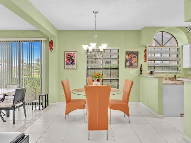 dining room with a textured ceiling, a notable chandelier, and light tile patterned flooring