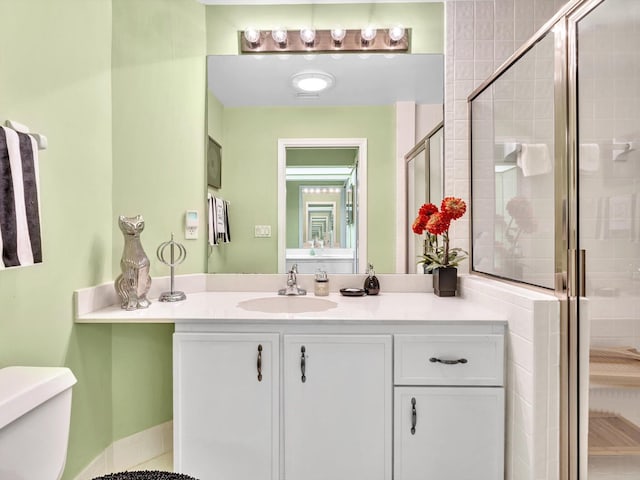 bathroom featuring vanity, toilet, and an enclosed shower